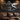 Metal sports wall art above a leather sofa in a man cave with warm lighting