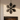 Metal snowflake wall ornament hanging above a modern fireplace mantel in a living room decorated for Christmas