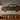 Man cave with large metal car silhouette art above a leather sofa, industrial pendant lighting