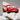 Red metal Lightning McQueen silhouette wall art mounted above a child's bed in a modern bedroom