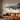 Large metal fighter jet wall art mounted above a leather sofa in a modern living room with warm lighting