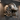 Metal football helmet wall art on a textured dark wall in a man cave with track lighting
