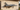 Metal fighter jet wall art on outdoor patio wall in sunlight