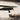 Black metal airplane silhouette mounted on a white brick patio wall