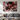 Large metal anime poster above sofa in bright living room with natural shadow play.