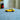 Close-up of a yellow toy car on a textured surface with blurred background indoors.