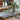 Elegant indoor setting with a potted plant on a leaf-patterned table in a cozy seating area.