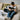 A young boy smiles while learning guitar with online lessons at home, sitting on a cozy bed.