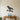 Black Crow Gripping a Crooked Branch Metal Wall Art on a light wall