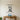 Electrician on a stepladder reaching for a hanging bulb