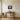 Mountain lake reflection metal wall art above a sofa