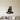 Black steel silhouette of a raccoon sitting on a log